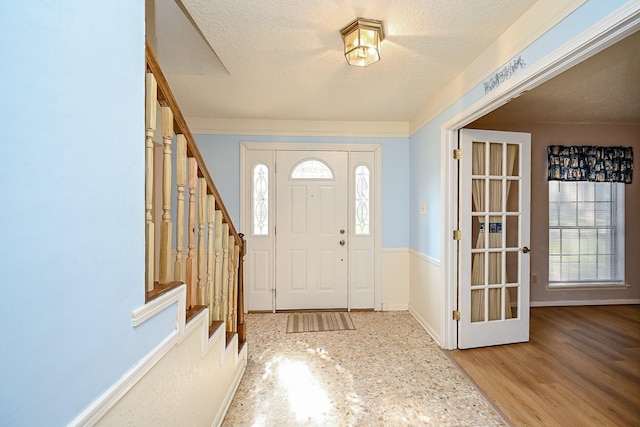 19515 Oak Timbers Dr, Humble, TX 77346 - entrance foyer with stairs, a textured ceiling, and baseboards