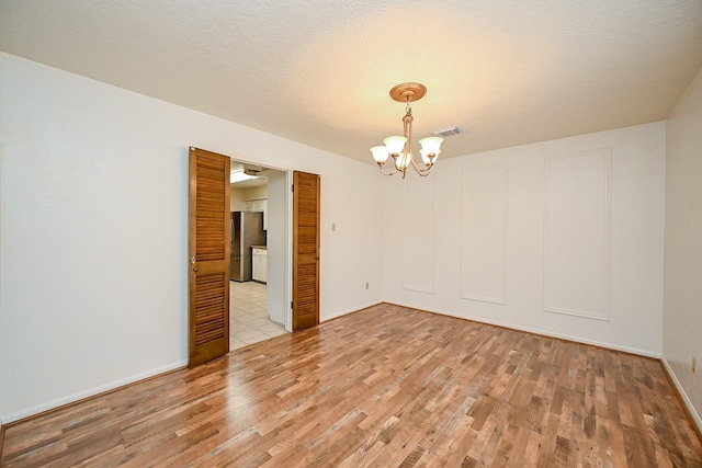 19515 Oak Timbers Dr, Humble, TX 77346 - unfurnished room featuring light wood finished floors, a chandelier, and baseboards