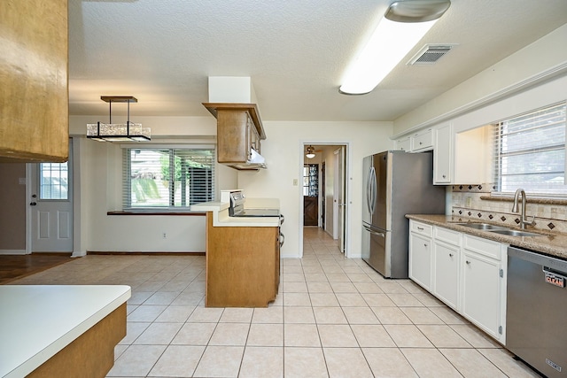 19515 Oak Timbers Dr, Humble, TX 77346 - kitchen featuring stainless steel appliances, a sink, white cabinets, and decorative backsplash