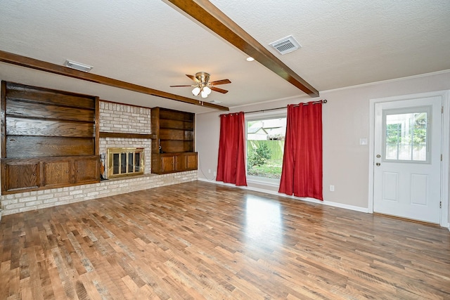 19515 Oak Timbers Dr, Humble, TX 77346 - unfurnished living room featuring a textured ceiling, beamed ceiling, wood finished floors, a ceiling fan, and baseboards
