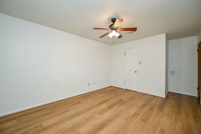 19515 Oak Timbers Dr, Humble, TX 77346 - unfurnished room with light wood-style floors, ceiling fan, baseboards, and a textured ceiling