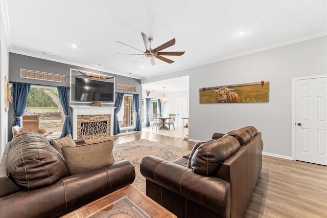3102 E Elm Cir, Katy, TX 77493 - living area with a ceiling fan, light wood-type flooring, a fireplace, baseboards, and crown molding