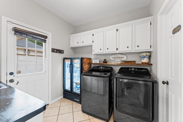 3102 E Elm Cir, Katy, TX 77493 - laundry area with washing machine and dryer, light tile patterned floors, baseboards, and cabinet space
