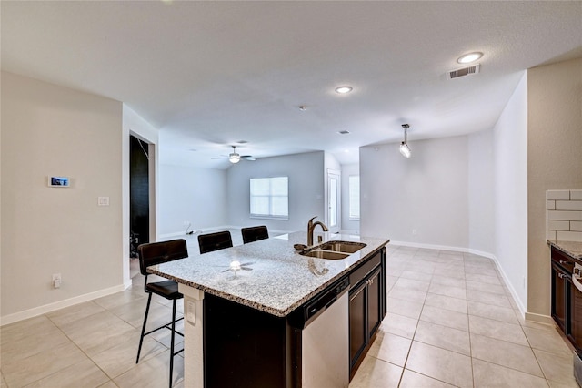 31702 Casa Linda Dr, Hockley, TX 77447 - kitchen featuring dishwasher, a breakfast bar, ceiling fan, light tile patterned flooring, and light stone countertops