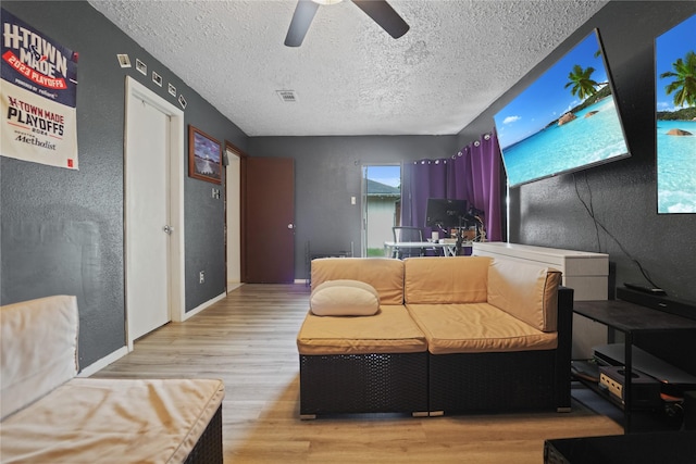 9228 Waving Fields Dr, Houston, TX 77064 - living area with light wood finished floors, ceiling fan, a textured ceiling, and a textured wall