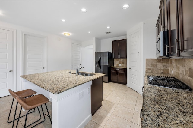 2206 Hidden Meadow Ln, Pearland, TX 77089 - kitchen with appliances with stainless steel finishes, a sink, backsplash, dark brown cabinets, and recessed lighting