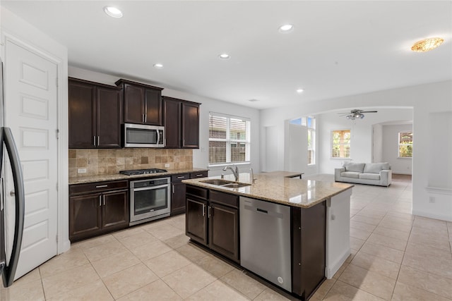 2206 Hidden Meadow Ln, Pearland, TX 77089 - kitchen featuring stainless steel appliances, a sink, light tile patterned floors, decorative backsplash, and recessed lighting