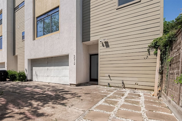 5012 Cornish St, Houston, TX 77007 - property entrance with an attached garage, concrete driveway, and stucco siding
