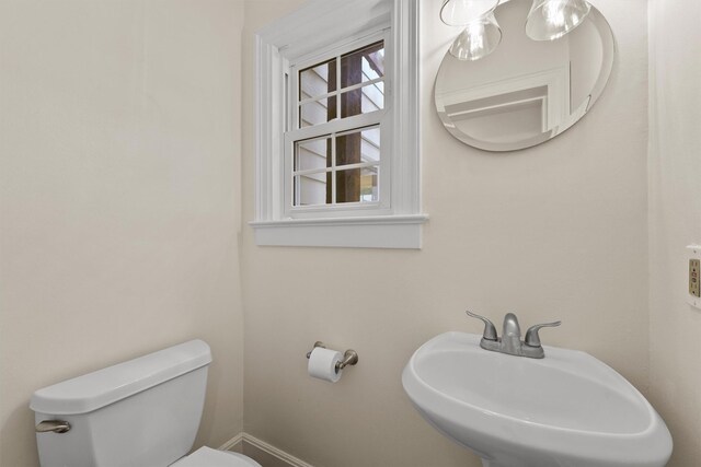 2044 Branard St, Houston, TX 77098 - half bathroom with a sink, toilet, and baseboards