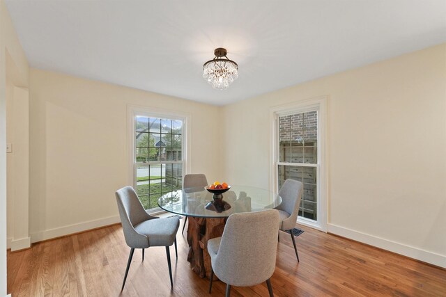 2044 Branard St, Houston, TX 77098 - dining room with baseboards, wood finished floors, and a chandelier