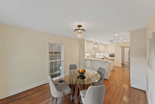 2044 Branard St, Houston, TX 77098 - dining room with light wood-type flooring, a chandelier, baseboards, recessed lighting, and a ceiling fan