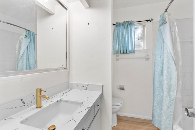 8903 Roos Rd, Houston, TX 77036 - bathroom featuring vanity, toilet, wood finished floors, shower / bathtub combination with curtain, and baseboards