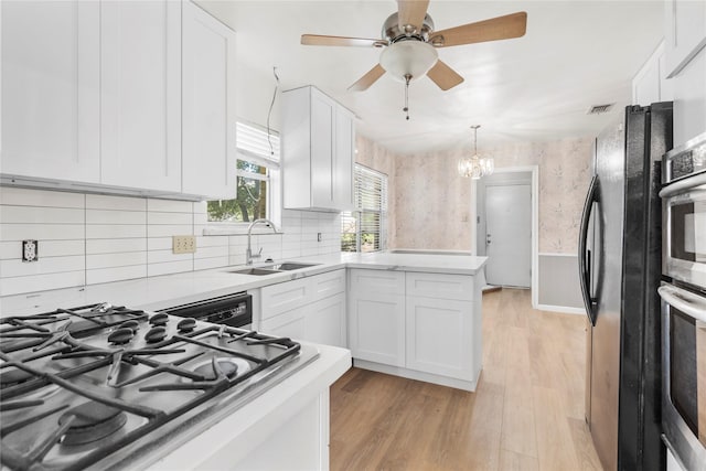 8903 Roos Rd, Houston, TX 77036 - kitchen with stainless steel appliances, a sink, white cabinets, light countertops, and light wood-type flooring