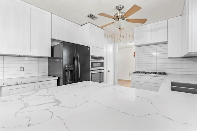 8903 Roos Rd, Houston, TX 77036 - kitchen with stainless steel appliances, white cabinetry, and decorative backsplash