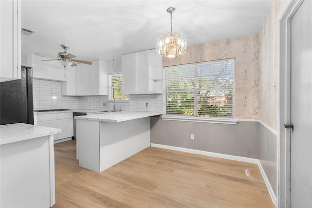 8903 Roos Rd, Houston, TX 77036 - kitchen with a sink, white cabinetry, freestanding refrigerator, a peninsula, and ceiling fan