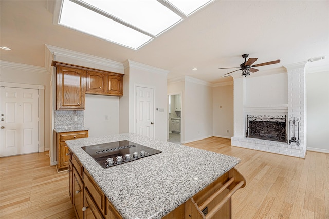 13223 Oregold Dr, Houston, TX 77041 - kitchen featuring black electric stovetop, a ceiling fan, brown cabinets, light stone countertops, and recessed lighting