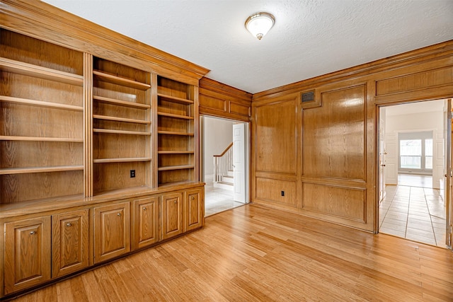 13223 Oregold Dr, Houston, TX 77041 - unfurnished room featuring light wood finished floors, wood walls, stairway, and a textured ceiling