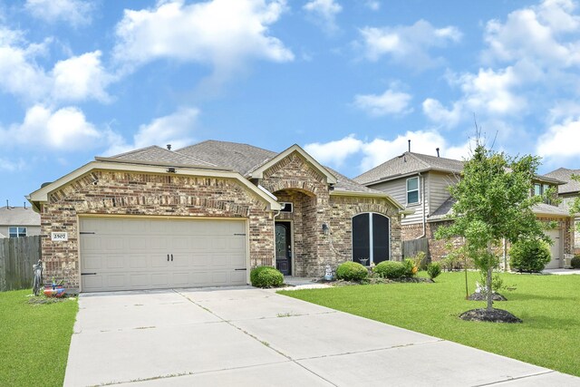 2507 Ocean Pass Ln, Richmond, TX 77469 - view of front of home with brick siding, driveway, a garage, and a shingled roof