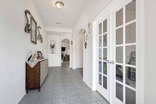 2507 Ocean Pass Ln, Richmond, TX 77469 - corridor featuring arched walkways, french doors, light tile patterned flooring, and baseboards