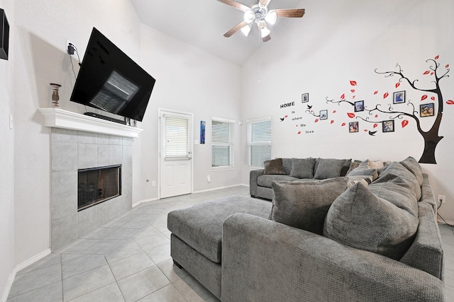 2507 Ocean Pass Ln, Richmond, TX 77469 - living area featuring a ceiling fan, light tile patterned floors, a fireplace, baseboards, and high vaulted ceiling