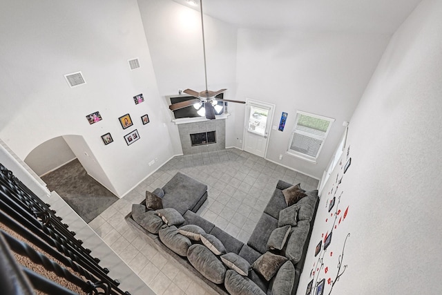 2507 Ocean Pass Ln, Richmond, TX 77469 - living area featuring a towering ceiling, a tiled fireplace, tile patterned flooring, ceiling fan, and baseboards