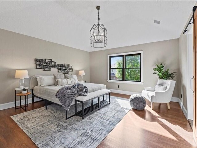 9622 Hanging Moss Trl, Houston, TX 77064 - bedroom with a chandelier, baseboards, a barn door, dark wood finished floors, and vaulted ceiling
