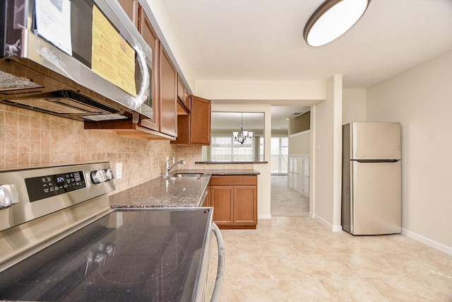 2367 Briarwest Blvd, Houston, TX 77077 - kitchen with freestanding refrigerator, stainless steel range with electric cooktop, brown cabinets, a chandelier, and tasteful backsplash