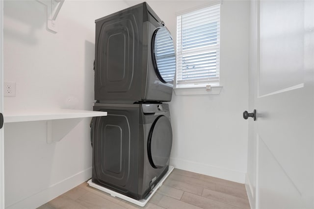 15147 Colorado Bend Park Dr, Cypress, TX 77433 - laundry room featuring stacked washer / drying machine, baseboards, and light wood-style flooring