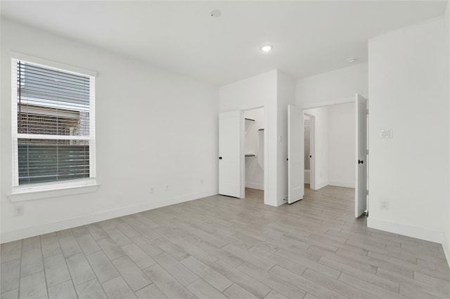 15147 Colorado Bend Park Dr, Cypress, TX 77433 - unfurnished bedroom with light wood-type flooring, baseboards, a spacious closet, and recessed lighting