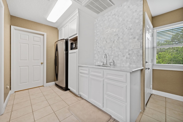 806 Quintana Roo Pl, Seabrook, TX 77586 - kitchen with a sink, freestanding refrigerator, light tile patterned flooring, light countertops, and white cabinets