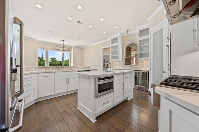 806 Quintana Roo Pl, Seabrook, TX 77586 - kitchen with beverage cooler, a sink, ornamental molding, decorative backsplash, and an island with sink