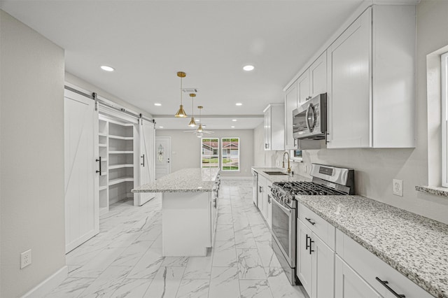 702 Norell St, Channelview, TX 77530 - kitchen with stainless steel appliances, a barn door, a sink, light marble finish flooring, and recessed lighting