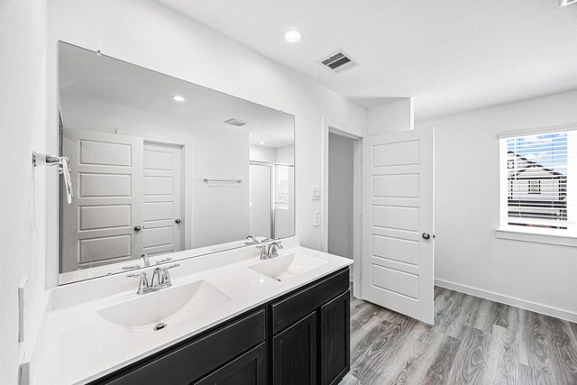 12305 Brandenburg Gate Dr, Houston, TX 77047 - bathroom with wood finished floors, double vanity, a shower, and recessed lighting