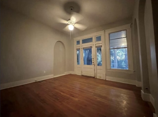2518 Grant St, Houston, TX 77006 - spare room featuring dark wood-type flooring, arched walkways, baseboards, and a ceiling fan