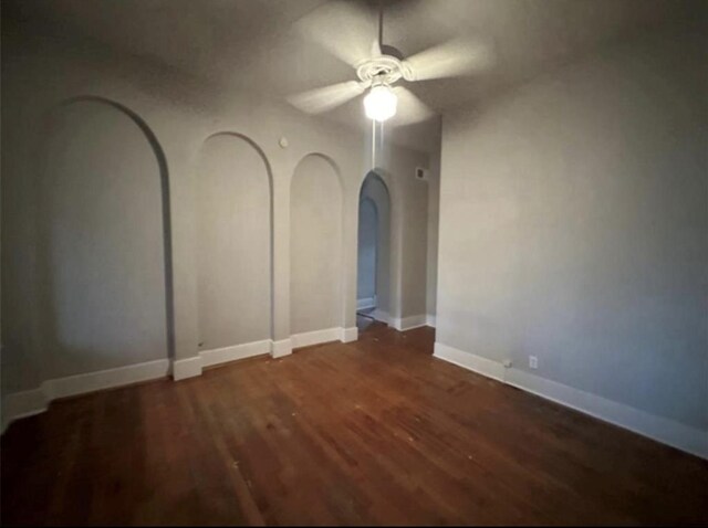 2518 Grant St, Houston, TX 77006 - empty room featuring a ceiling fan, arched walkways, wood finished floors, and baseboards