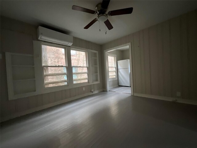2518 Grant St, Houston, TX 77006 - unfurnished room with an AC wall unit, a ceiling fan, and wood finished floors