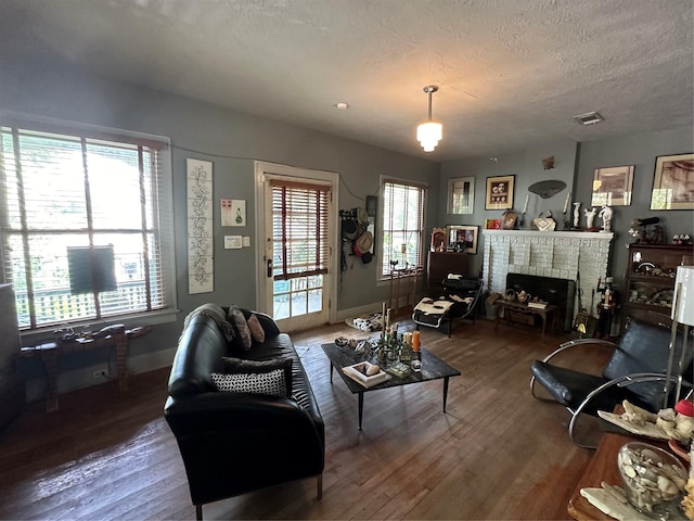 1004 Missouri St, Houston, TX 77006 - living room with wood finished floors, a brick fireplace, baseboards, and a textured ceiling