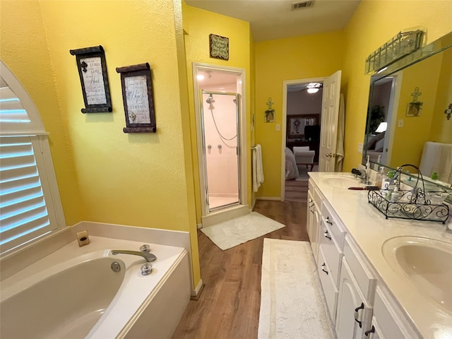 11683 Lakeshore Dr, Thornton, TX 76687 - ensuite bathroom featuring a shower stall, wood finished floors, a bath, and double vanity