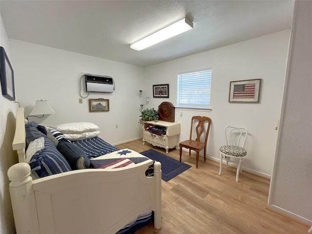 11683 Lakeshore Dr, Thornton, TX 76687 - living area featuring light wood finished floors, an AC wall unit, and baseboards