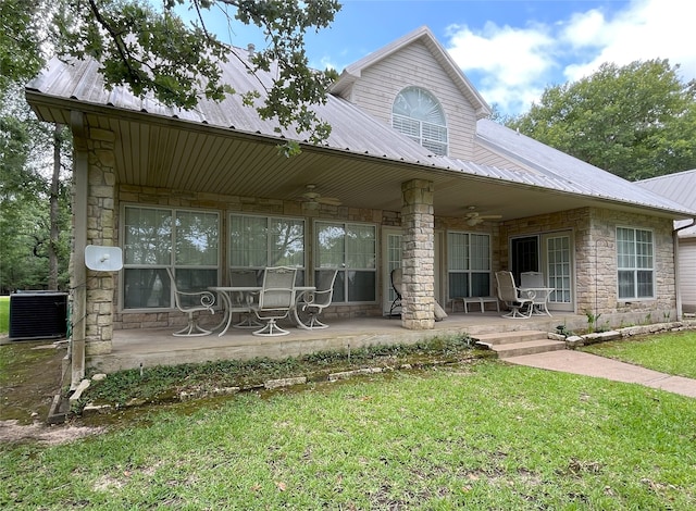 11683 Lakeshore Dr, Thornton, TX 76687 - back of house featuring a ceiling fan, stone siding, metal roof, central air condition unit, and a lawn