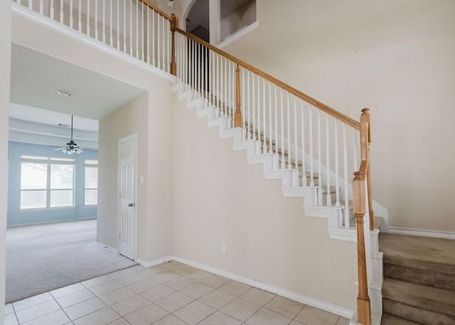 4615 Long Climb Cyn, Humble, TX 77396 - stairway featuring carpet, ceiling fan, tile patterned flooring, baseboards, and a high ceiling