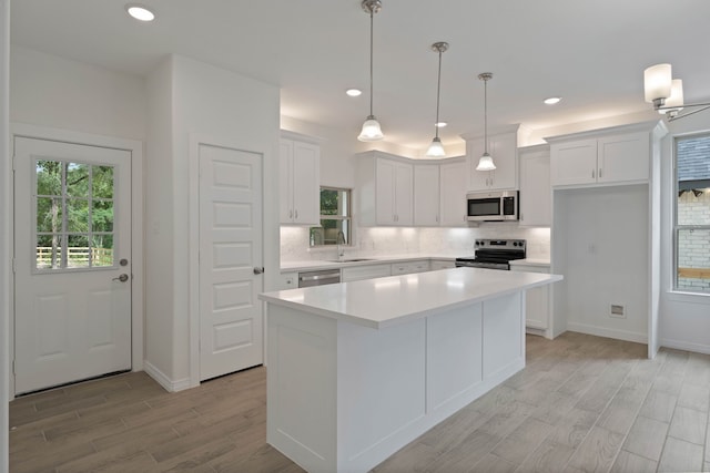 24696 Wicklow Rd, Hempstead, TX 77445 - kitchen with appliances with stainless steel finishes, a sink, light wood-style floors, tasteful backsplash, and white cabinetry
