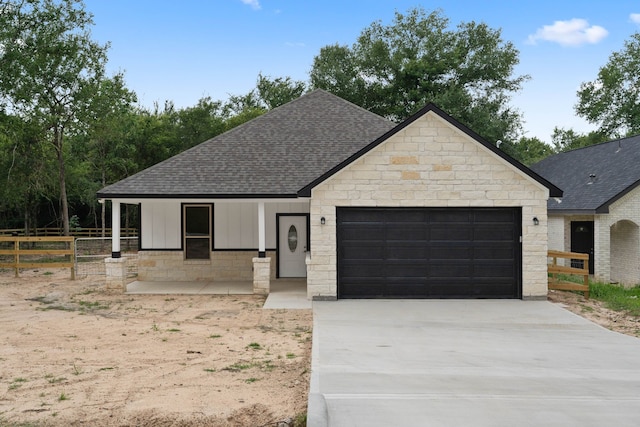 24696 Wicklow Rd, Hempstead, TX 77445 - view of front of home featuring roof with shingles, an attached garage, driveway, and stone siding