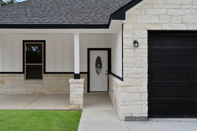 24696 Wicklow Rd, Hempstead, TX 77445 - view of exterior entry featuring roof with shingles, stone siding, and board and batten siding