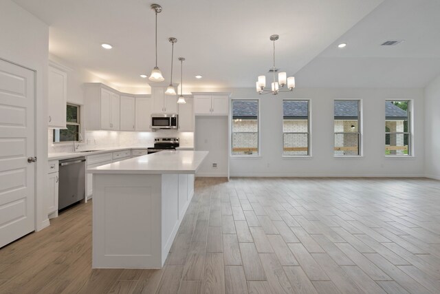 24696 Wicklow Rd, Hempstead, TX 77445 - kitchen featuring stainless steel appliances, a sink, light wood finished floors, tasteful backsplash, and white cabinets