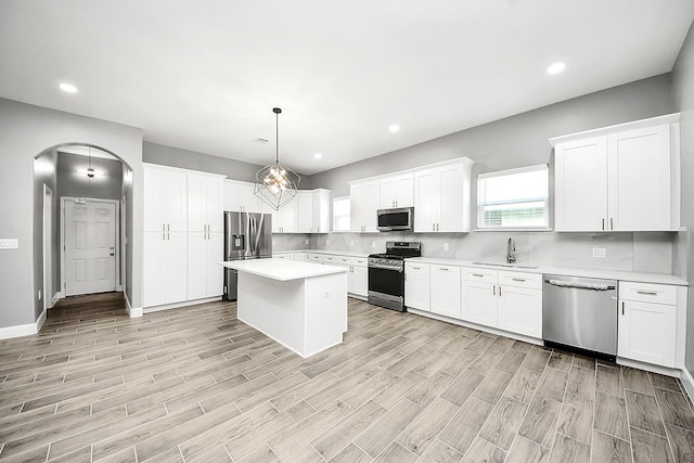 2448 Areba St, Houston, TX 77091 - kitchen with appliances with stainless steel finishes, a sink, light countertops, arched walkways, and light wood finished floors