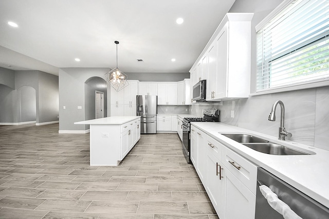 2448 Areba St, Houston, TX 77091 - kitchen with stainless steel appliances, a sink, arched walkways, a center island, and recessed lighting