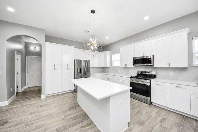2448 Areba St, Houston, TX 77091 - kitchen featuring appliances with stainless steel finishes, wood finish floors, arched walkways, light countertops, and recessed lighting