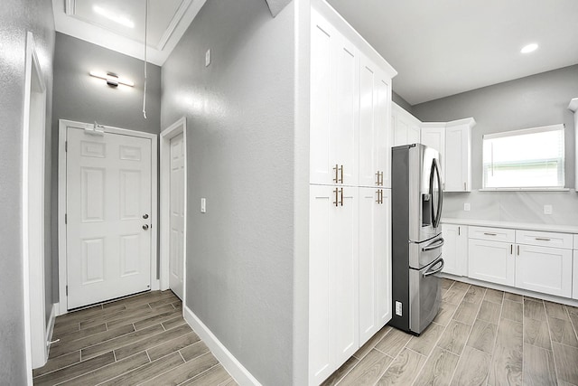 2448 Areba St, Houston, TX 77091 - kitchen featuring stainless steel fridge, wood finish floors, white cabinets, light countertops, and baseboards