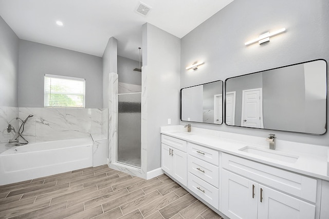 2448 Areba St, Houston, TX 77091 - bathroom with double vanity, a garden tub, a stall shower, wood finished floors, and baseboards